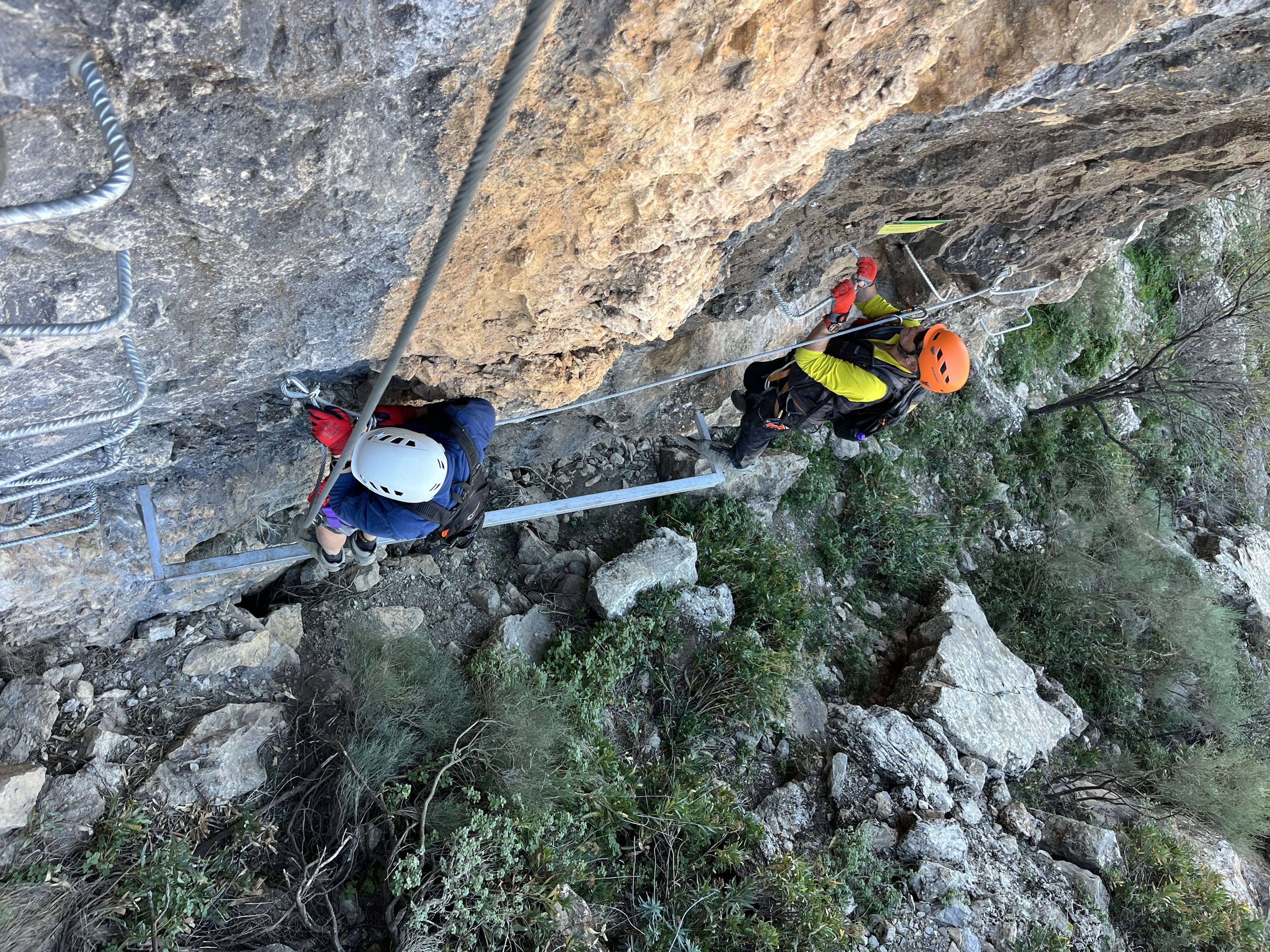 2 people practice via ferratas in Andalucia. Steep ladders, cables and zip lines