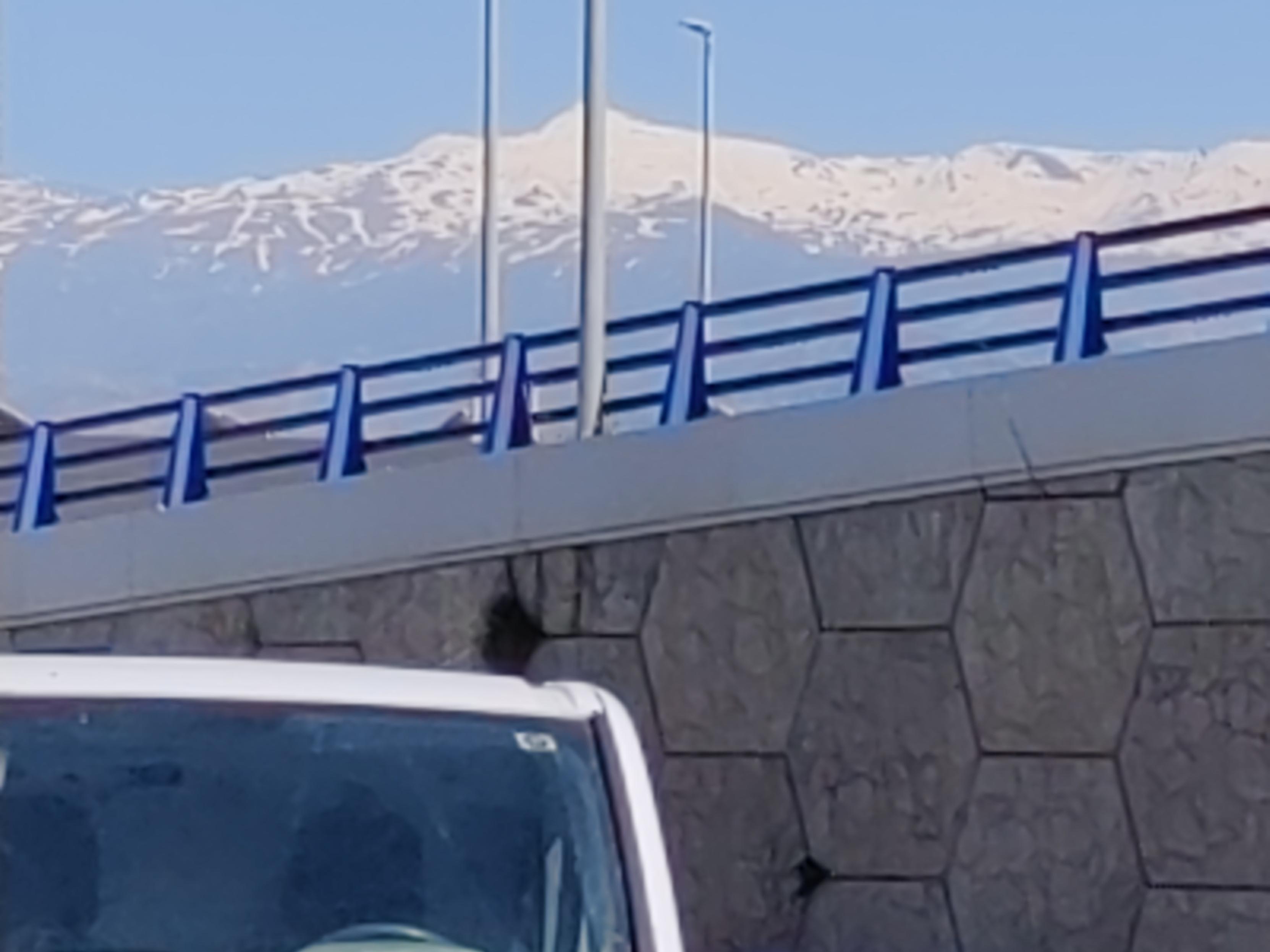 View over a motorway towards some snow covered mountains