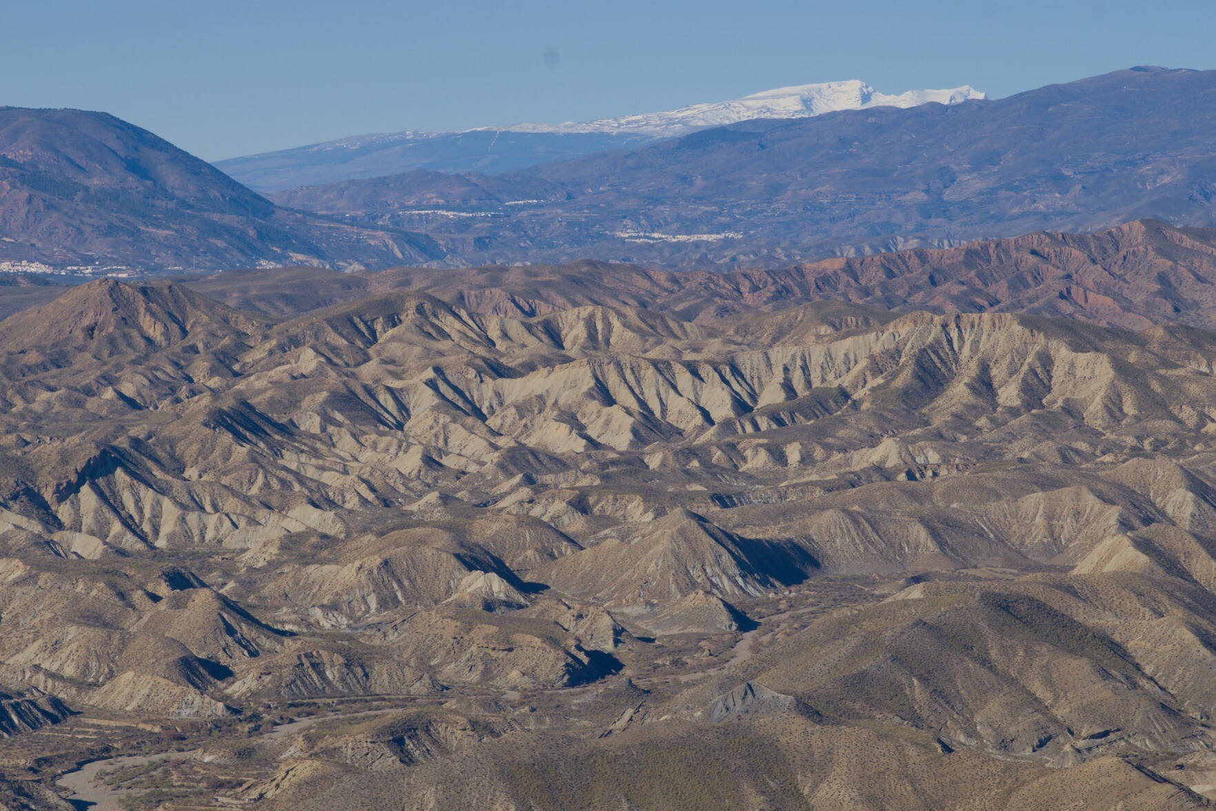 Desert badlands and high mountains, Andalucia has it all!. Mulhacén and Alcazaba in the Sierra Nevada seen today from 80km away to the east from the summit of Cerro Alfaro, Tabernas, Almeria.
