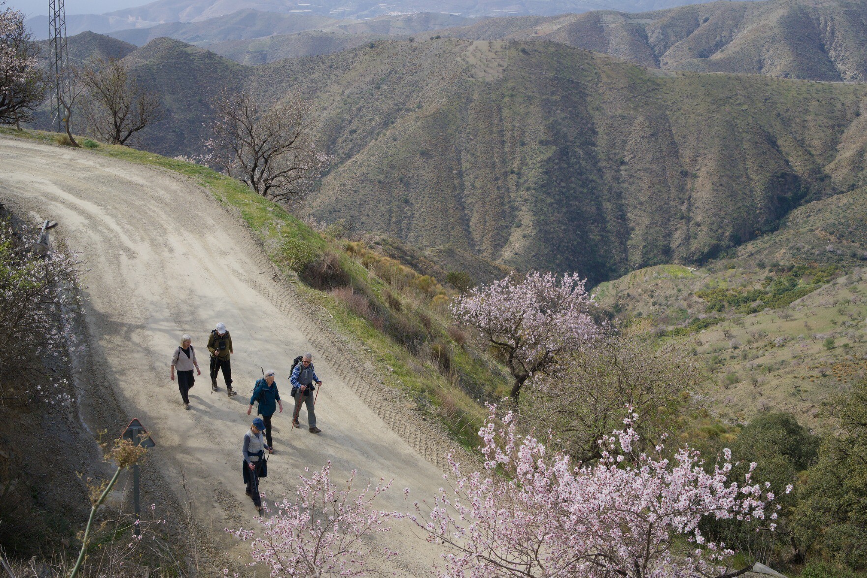 Hikers walking down a trail leading to the village of Polopos