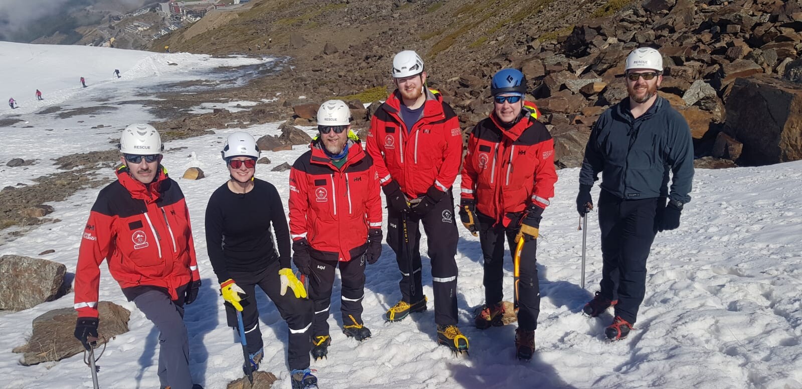 Mountain Rescue team members training in the snow with helmets and crampons