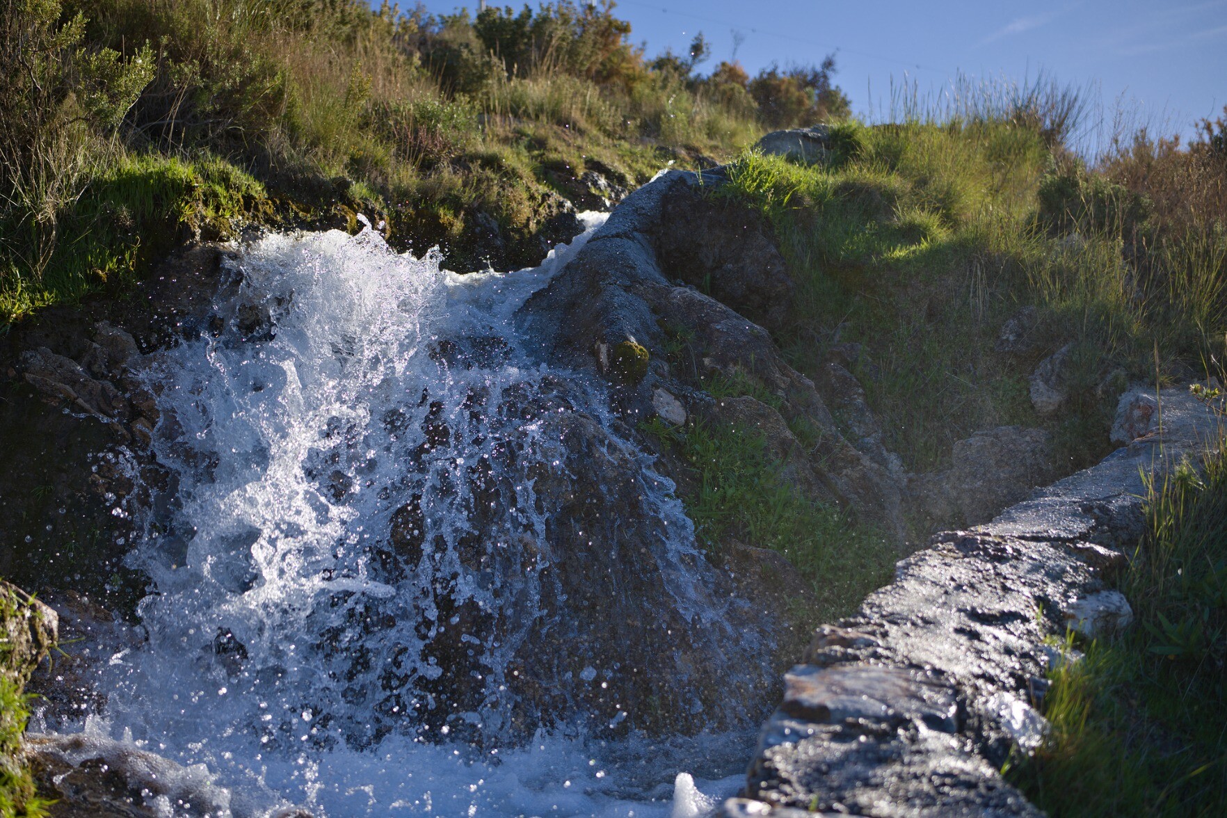 A small waterfall lit up by the morning sun