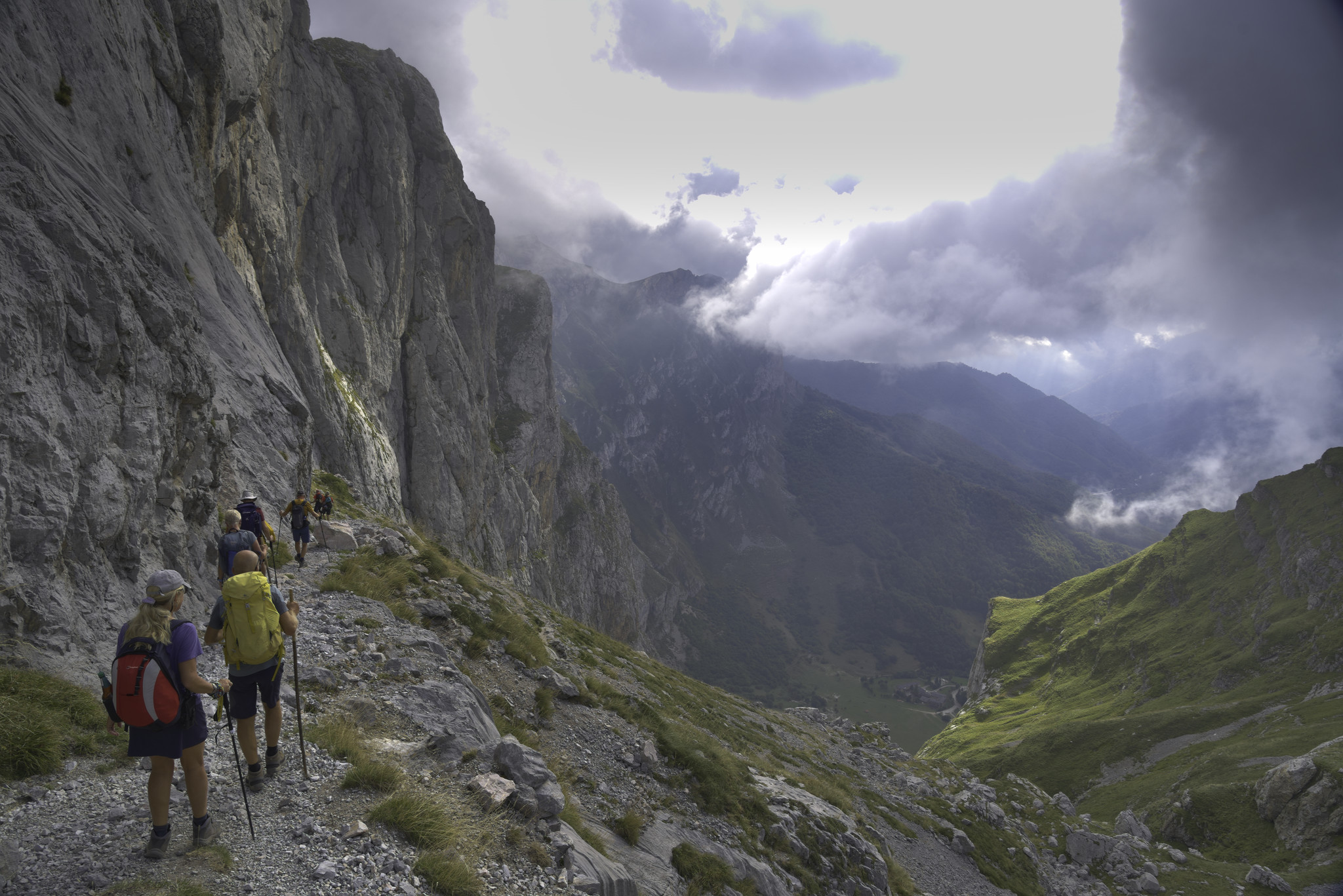 The start of the very steep descent to Fuente Dé. Bad weather dark cloud gather to the right. The green fields of Fuente De can be see below 