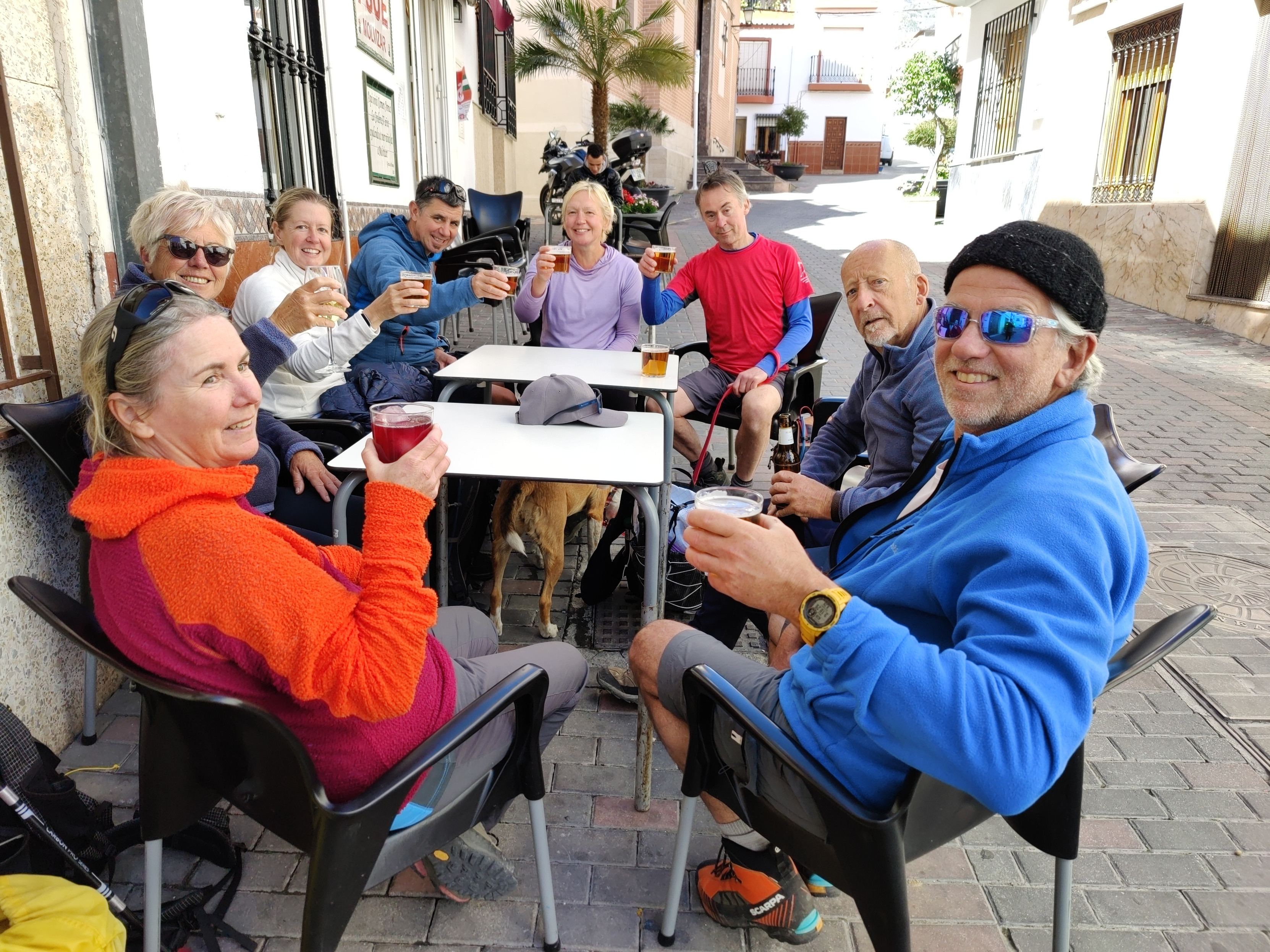A group of tired hikers enjoys a cool beer outside a small town bar