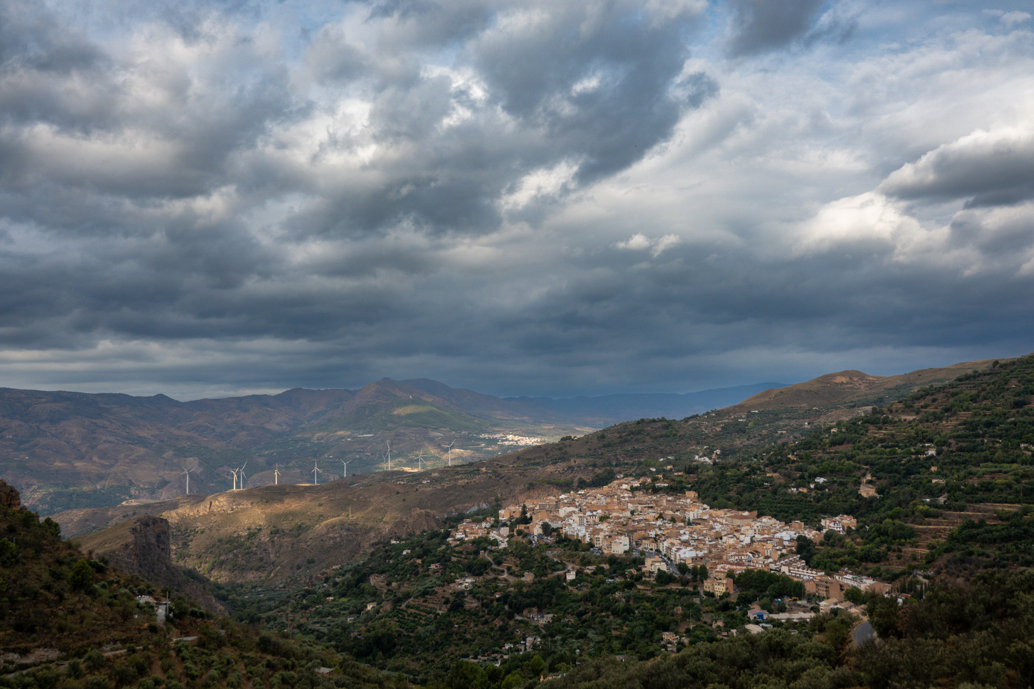 Sun shining on a small Spanish town. Cloudy all around