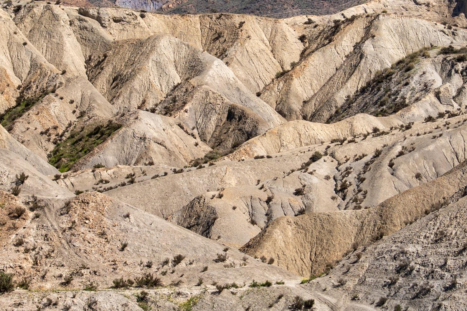 A scene looking into an arid, dry twisted scenery of ridges and ravines