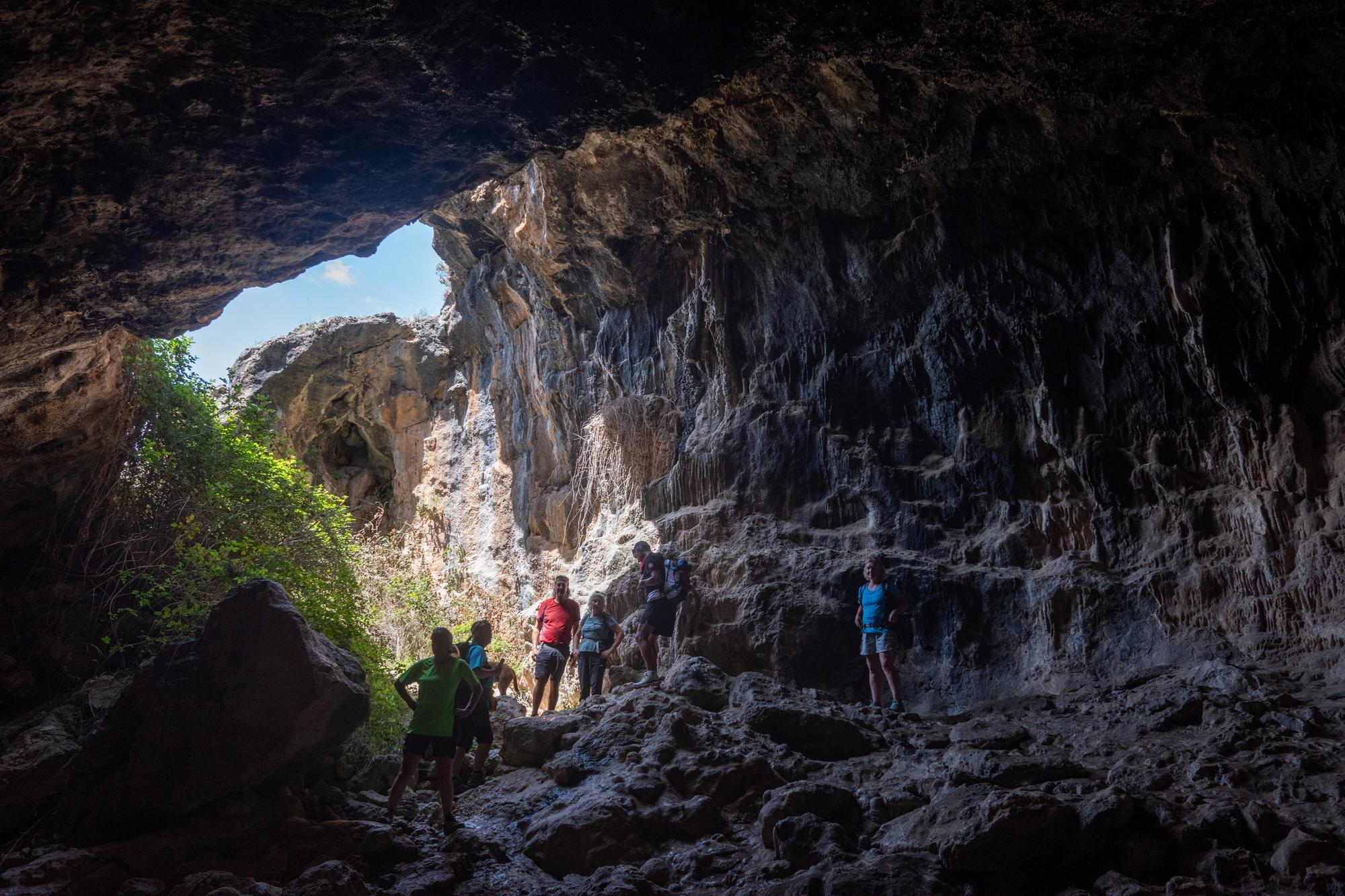 A group stand at the entrance to a large cave system