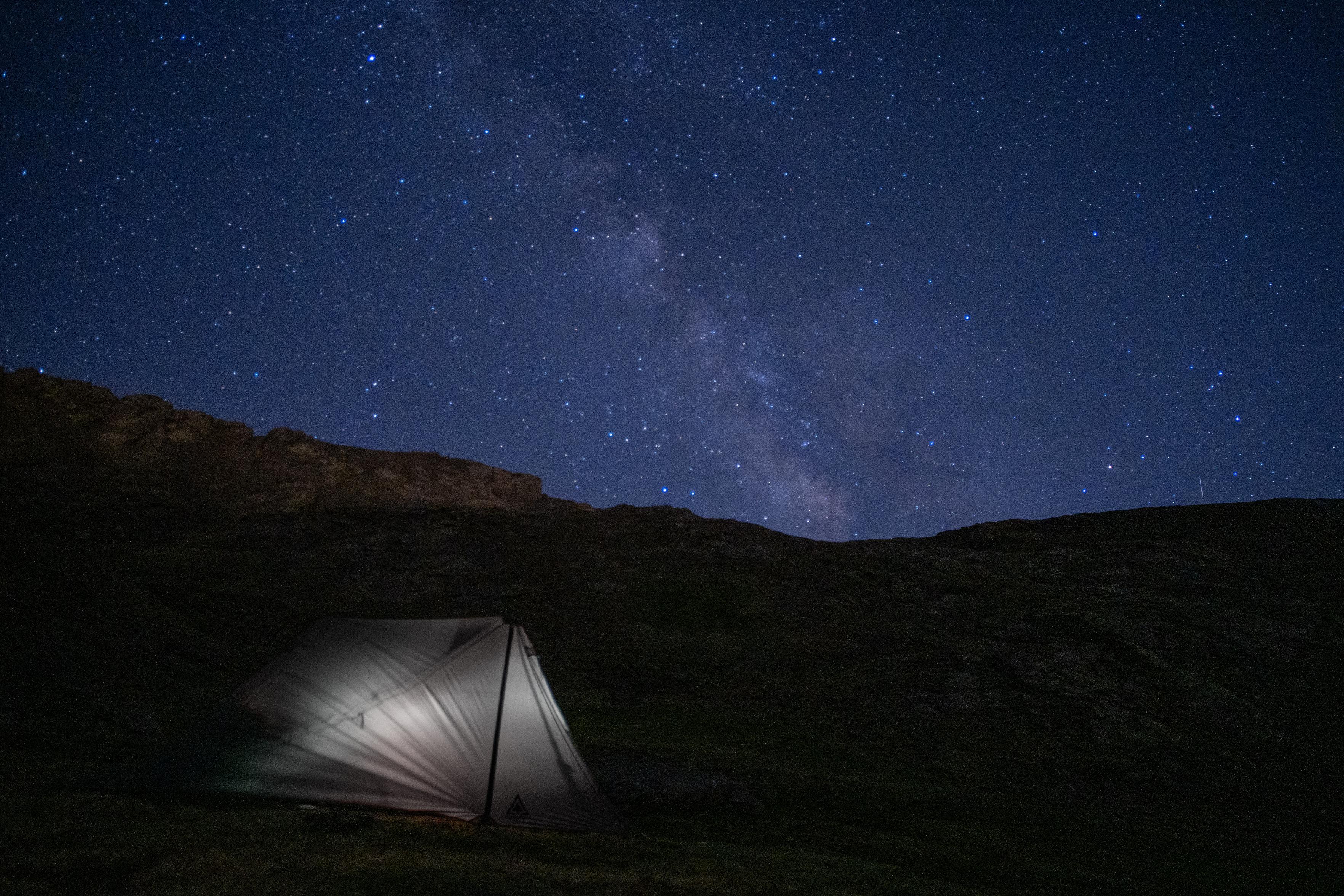 A lonely tent on a high plateau in a quiet part of Spains Sierra Nevada is the perfect place to view the night skies. Here is the Milkyway. A light shines in the tent