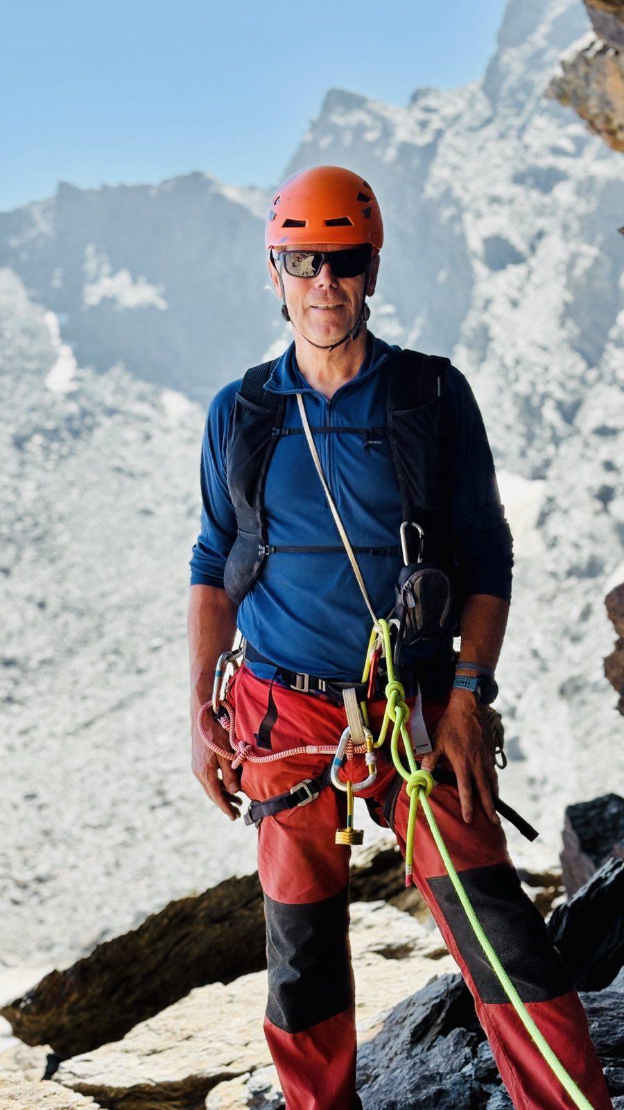 El Perro Negro stands attached to a yellow rope. He has orange helmet, blue top and red trousers.