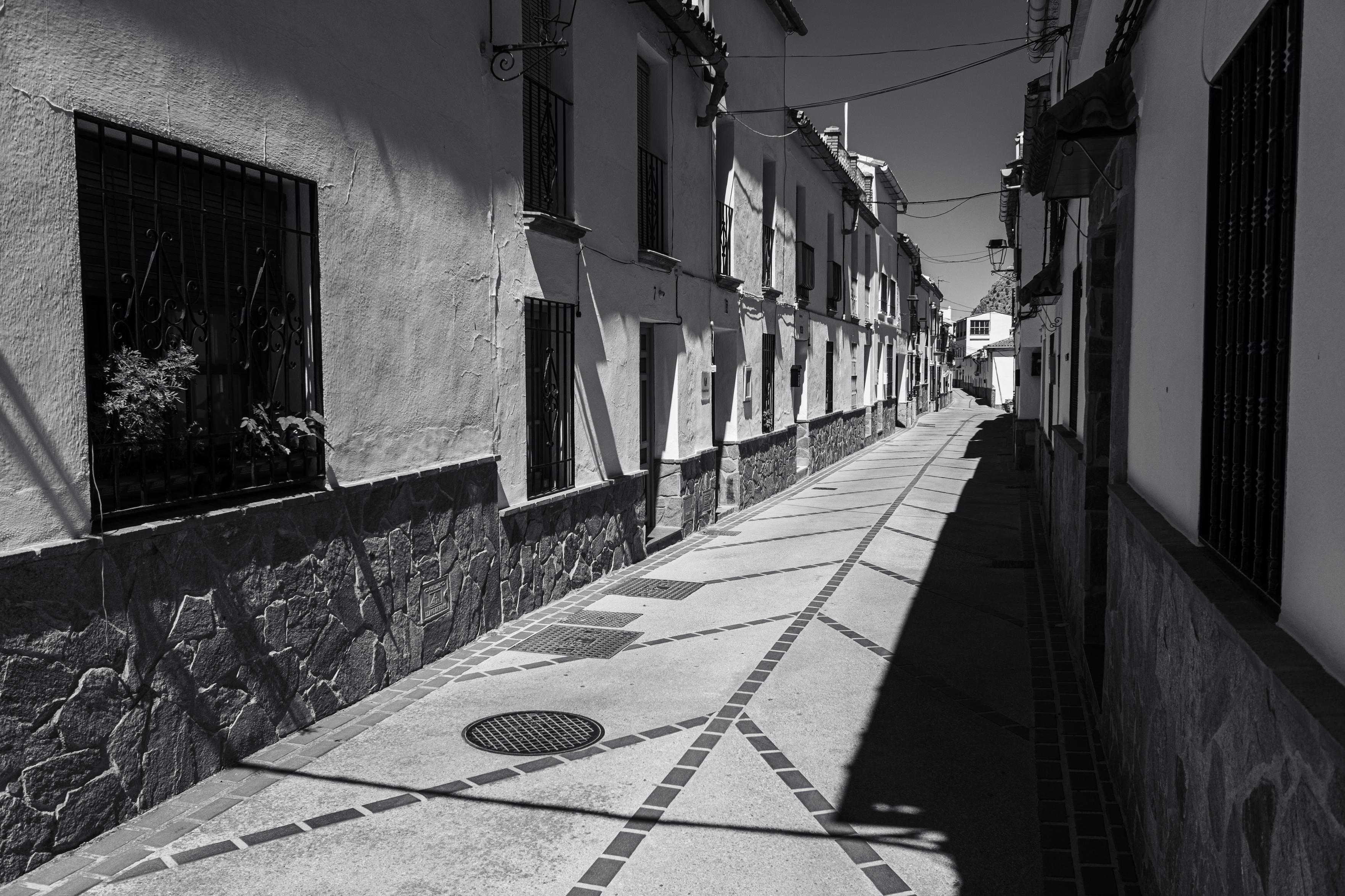 Black and white lines along a street throwing dark and sharp shadows